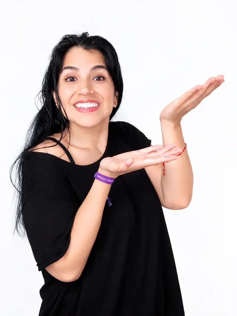 Angela Pacheco sonriendo y señalando hacia el texto
